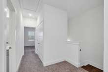 Upstairs View. 2 Bedrooms behind this shot, Full Half Bath on left, Tiled Laundry on Right, Primary Suite straight ahead. (Photo is of previous townhome built. It is the same floor plan, but interior finishes may vary).