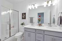 Primary Ensuite Bath Equipped with Dual Vanities. (Photo is of previous Townhome built. It is the same floor plan, but interior finishes may vary).