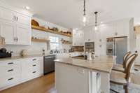 Completely remodeled kitchen with open shelving, quartzite counters, electric built in cooktop and deep cabinets.
