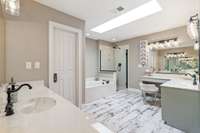 Remodeled 2nd Primary Bathroom with 2 separate vanities and cosmetic sitting area.