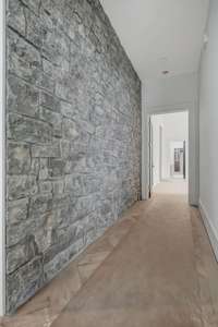 Custom stone wall upon entry to primary bedroom.