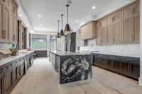 Gourmet kitchen is equipped with top-of-the-line Thermador appliances, custom white oak shaker cabinetry and beautiful island w/waterfall edge.