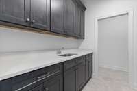 Laundry Room with plenty of cabinets and walk-in storage closet