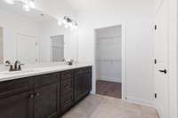 Primary bedroom with double vanities and walk-in closet