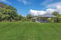 Barn features 2 Large Garage Bay Style Doors + Covered/Open Area