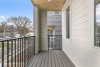 Balcony off the kitchen with Trex decking and custom metal railing for relaxing outdoors