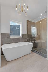 Primary bath with frameless shower glass and freestanding tub with deck mounted faucet