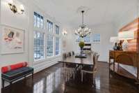 A formal dining room adjacent to the foyer with impressive windows allowing for natural light