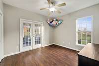 2nd bedroom downstairs with doors that lead to screened in back patio