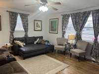 Living Room with Hardwoods re-finished in "2022", Ceiling Fan, Sunny Large Windows.