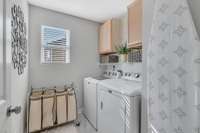 The nice laundry room has added cabinets for storage.