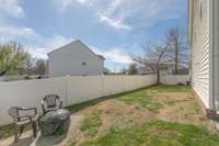 Alternate view of the side yard space with a small patio area perfect for a firepit or extra seating area.