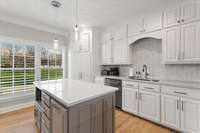 Contrasting paint on the prep island keeps this space feeling warm with its bright white quartz and marble tile.