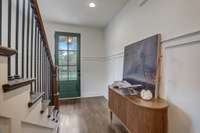 Inviting foyer with wall molding and gleaming genuine hardwood