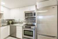 This modern galley kitchen offers stainless steel counter tops and appliances.