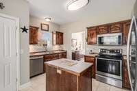 Alternate view of the kitchen, highlighting the sink at window, prep island, and view of the double door, oversized kitchen pantry location.