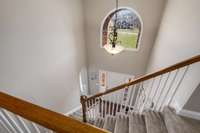 View of two story entry foyer with (newly) carpeted steps to second floor.