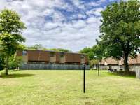 A view of the large courtyard area that has mature trees, picnic areas, community grills, and walkways.