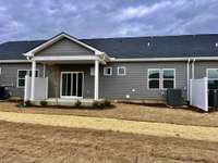 A covered back porch in a private back yard setting. The homes yard is fully sodded and maintained by the HOA. Never cut your grass again!