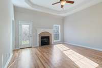 Living room includes high trey ceilings, hardwood floors, and a fireplace for warm and cozy nights.