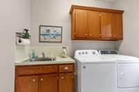 Laundry & Mud Room with custom sink vanity; Cabinets and hanging shelves for storage; Washer/Dryer are negoitable