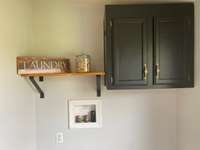 Just off the kitchen is the oversized laundry area, includes a decorative shelf and cabinet.