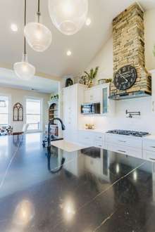 Black quartz countertop on the island with farmhouse sink