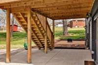 Potentially screen in this area under the deck or maybe hang a swinging chair and ceiling fan for the hot summer days. Bonus room access is to the right.