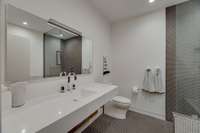 Sleek and fun bathroom upstairs with a zero entry shower and separate soaking tub.