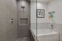 Sleek and fun bathroom upstairs with a zero entry shower and separate soaking tub.