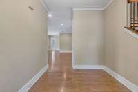 Welcome Home to this large entry foyer featuring tall baseboards and crown molding and finished wood floors.