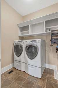 The Laundry Room is conveniently located downstairs and features tile floors, Wood shelving, and a Laundry Sink.  The Washer and Dryer Remain.