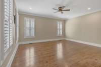 First Floor Owners Suite with Crown molding, Ceiling Fan and Door leading out to the covered Entertainment Area.