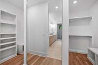 A large mirror divides the dual sided primary closet with custom built-ins