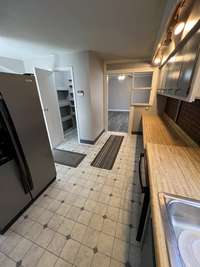 Galley style kitchen with large eating area behind the refrigerator