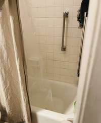 Shower/Bathtub Combination with porcelain bathtub and tile surround.