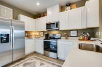 Another view of the kitchen. Pictures are of previously completed home of same floorplan. Features may vary. Listed home will have gray cabinets. Refrigerator not included.