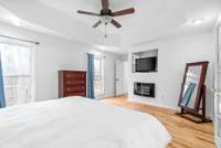 Primary bedroom with the hardwood floors and an electric fireplace for chilly mornings,