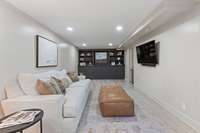 Built in bookcases and cabinet storage in basement level family room.