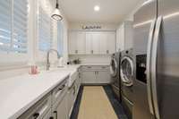Who would not want to do laundry in here? Farm sink and room for a fridge