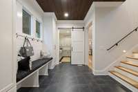 The stained plank ceiling and custom barn door make even this work space elegant.  A huge storage closet is under the second staircase