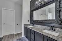 Primary ensuite features granite a double vanity, walk in closet and shiplap feature wall.