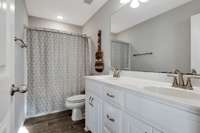 Upstairs bathroom has tub/shower combo and double vanities.