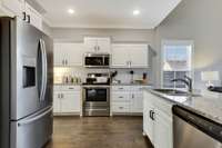 Light and bright kitchen with white cabinets and granite countertops.