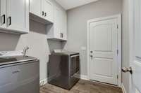 Laundry Room has been upgraded with upper cabinets for storage.