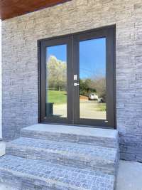 The exterior of the front entrance with nice stone work surrounding the area to give it an extra elegant touch