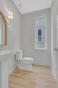 Half bath on main level with hardwoods and pedestal sink