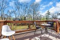 Sunny back deck connects to the sunroom, and has stairs down to the driveway