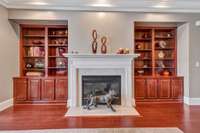 Living room with gas fireplace and built in book shelves.