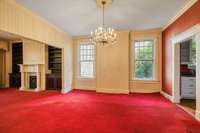 Formal living and dining rooms with original unfinished hardwood flooring under the wall to wall carpet and pad.